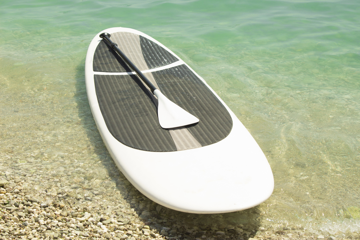 Paddle board and paddle on the coastline.